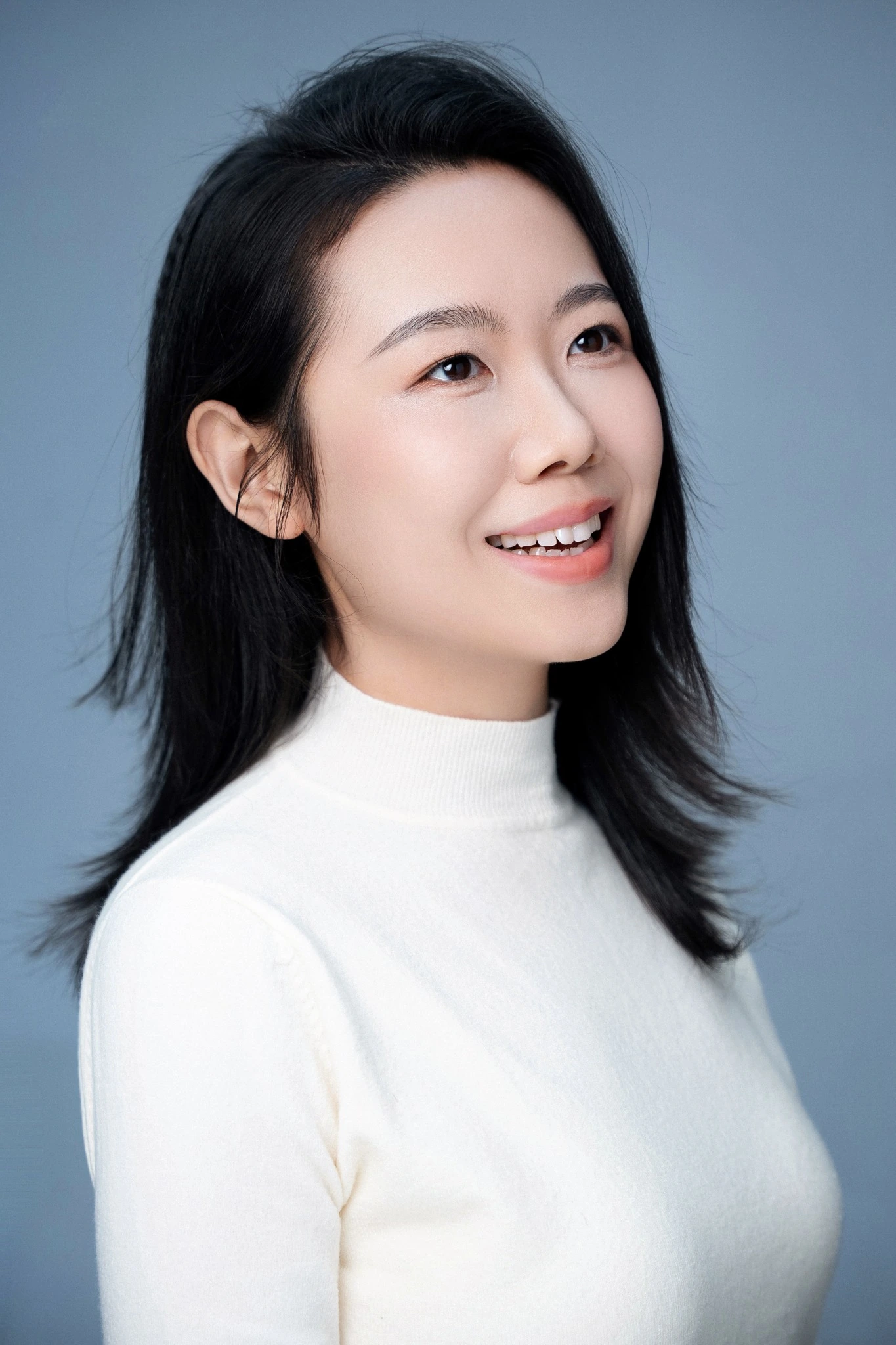 Victoria Wang 的人物肖像:身穿白色高领上衣、自然微笑